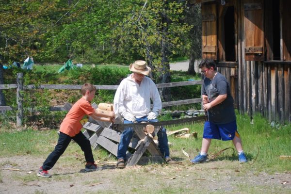 Kids crosscut sawing.