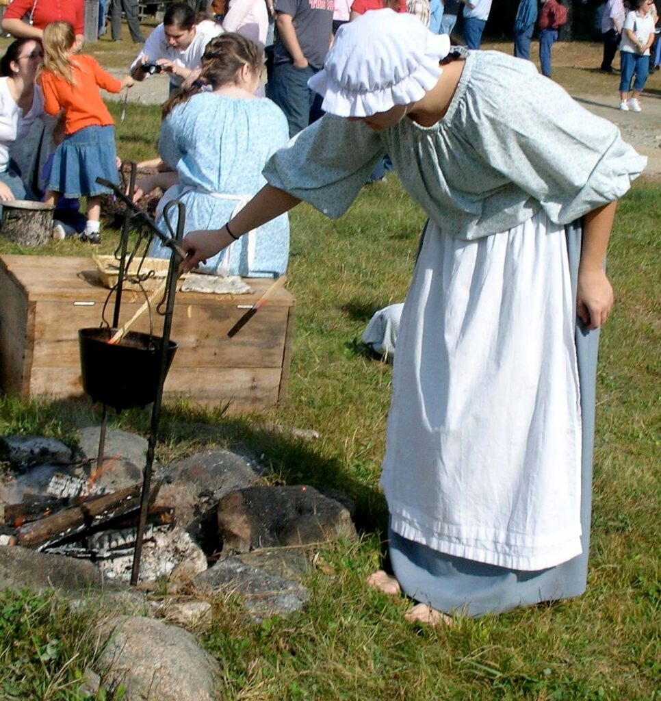 Re-enactor making candles.